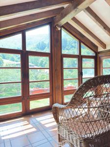 a room with two wicker chairs in front of windows at Explora Picos de Europa in Cosgaya