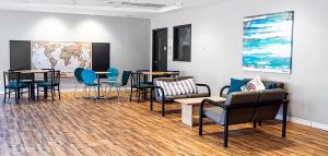 a waiting room with tables and chairs and a map on the wall at Hébergement Résidence de La Cité in Ottawa