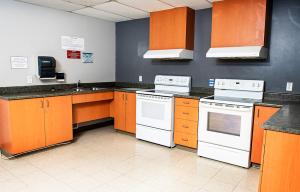 a kitchen with orange cabinets and white appliances at Hébergement Résidence de La Cité in Ottawa