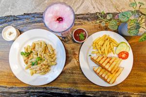 a wooden table with two plates of food and fries at FabHotel Kzar Select - Nr US Consulate in Kolkata