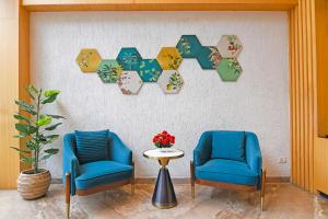 two blue chairs and a table in a room at FabHotel Kzar Select - Nr US Consulate in Kolkata