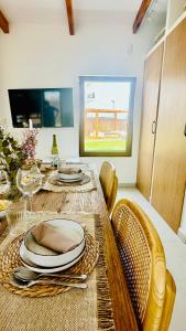 a dining room table with chairs and plates on it at Villa Salinas Beach Home Natural Park in La Manga del Mar Menor