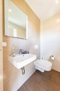 a white bathroom with a sink and a toilet at Premiumferienhaus Vanua in Hasselfelde