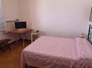 a bedroom with a bed and a desk with a computer at Villa Adele in Trappeto