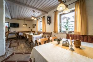 a restaurant with tables and chairs and a large window at Hotel Garni Kapellenstüberl in Raubling