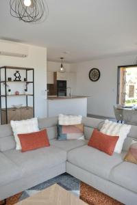 ein Wohnzimmer mit einem grauen Sofa und bunten Kissen in der Unterkunft Alivu bergerie Sotta hyper cosy in Sotta + 21 Fotos