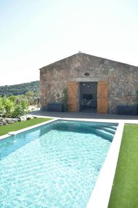 einen Pool vor einem Steinhaus in der Unterkunft Alivu bergerie Sotta hyper cosy in Sotta