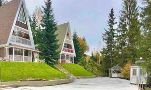 una grande casa con una torre in cima a un cortile di Цілий триповерховий будинок FREEMAN-3 над річкою з альтанкою та грилем a Bukovel
