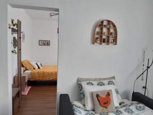 a living room with a chair and a bed at Hiša Tarka in Dobrovnik