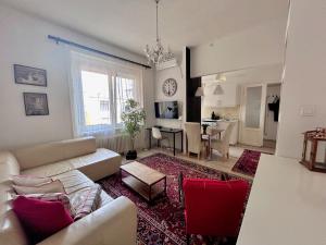 a living room with a white couch and red chairs at Standard Apartment by Hi5 - Károly 23 in Budapest