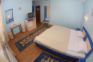a bedroom with a bed and a tv in it at Pensiunea Maria , Floresti in Floreşti
