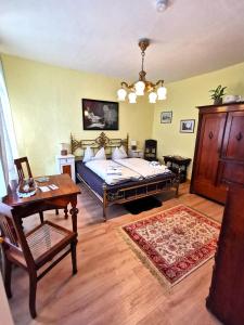 a living room with a bed and a table at Pension im Tal der Stille - Thale OT Treseburg in Thale