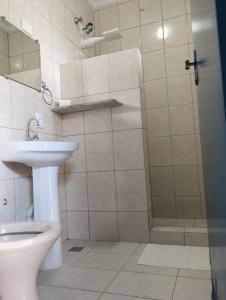 une salle de bain avec une douche, des toilettes et un lavabo dans l'établissement Pousada DONA DUTRA, à Lençóis Paulista