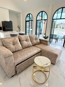 a living room with a brown couch and a table at N&C Mountain Pool Villa Huahin in Hua Hin