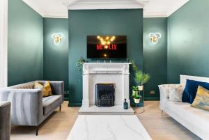 a living room with a fireplace with a tv on top at New! - The Most Central and Lux Whitby House - Hot-Tub in Whitby