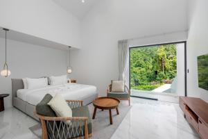 a bedroom with a bed and a chair and a window at Seaview Dream Villa in Chaweng Noi Beach +50 photos