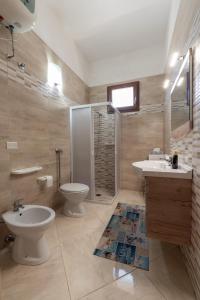 un bagno con wc, lavandino e doccia di Villetta al mare a Marina di Mancaversa