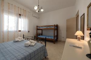 una camera da letto con un letto con asciugamani sopra di Villetta al mare a Marina di Mancaversa