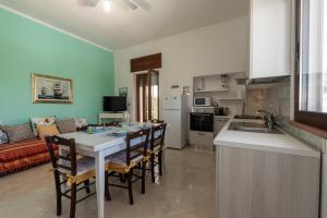 una cucina e un soggiorno con tavolo e sedie di Villetta al mare a Marina di Mancaversa Altre 18 foto