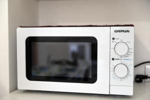 un forno a microonde bianco seduto sopra un bancone di Villetta al mare a Marina di Mancaversa