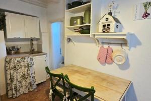 a kitchen with a wooden table and a dining room at Le Allegre Comari di Nesso, casa e benessere in Nesso
