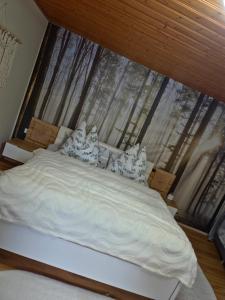 a bed with white sheets and pillows in front of a window at Green Home in Furth im Wald