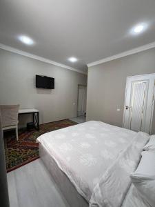una camera con letto bianco e TV a schermo piatto di Старый Город гостница a Tashkent