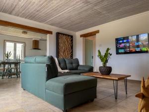 een woonkamer met een bank en een tv bij Garden Terrace Menas Authentic Wellness Eco in Noord