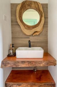 een badkamer met een witte wastafel en een spiegel bij Garden Terrace Menas Authentic Wellness Eco in Noord