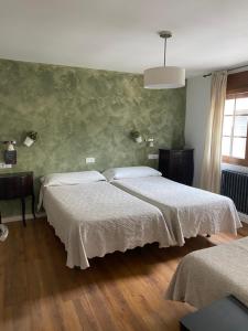 a bedroom with two beds in a room at As Miguiñas do Cebreiro in Pedrafita do Cebreiro