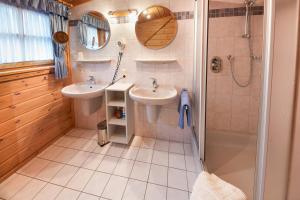 a bathroom with two sinks and a shower at Ferienwohnungen Fausts Blockhaus in Schmallenberg +17 photos