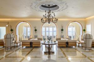 uma sala de estar com um lustre e uma mesa e cadeiras em Saint John Hotel Villas & Spa em Agios Ioannis Mykonos