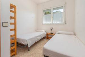 2 camas en una habitación con escalera y ventana en Casa Lago de Banyoles, en Banyoles