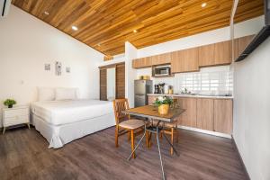 una camera da letto con un letto, un tavolo e una cucina di Macondo Ecolodge Apt 1 - Heliconia a Coco