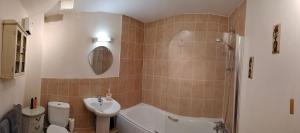 a bathroom with a tub and a sink and a toilet at Canalside Chic Your London Escape Starts Here WIFI and Airport Transfers in Hemel Hempstead