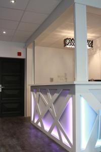 une cuisine avec un comptoir à éclairage violet dans l'établissement Hôtel - Restaurant Eugenie, à Pontorson