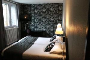 - une chambre dotée d'un lit avec un mur à motifs dans l'établissement Hôtel - Restaurant Eugenie, à Pontorson