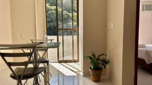 a room with a table with a plant and a window at 600m da UFV e 100m da rodoviária in Viçosa