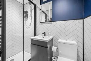 a bathroom with a sink and a toilet and a mirror at New! - The Most Central and Lux Whitby House - Hot-Tub in Whitby +59 photos