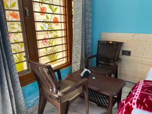 a room with two chairs and a table and a window at Ganga Valley Homestay in Chakrāta