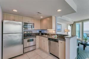 a kitchen with stainless steel appliances and wooden cabinets at Spacious 2 Bedroom Oceanview Condo! 9th Floor Views! Oceans One 908 in Myrtle Beach