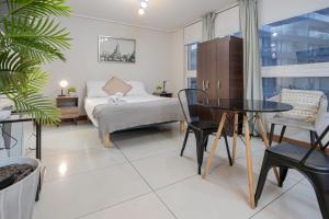 a living room with a bed and a table and chairs at Delightful Studio Apartment in Las Condes in Santiago
