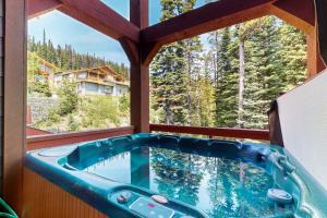 a hot tub in a room with a window at Snowbanks 2 in Big White