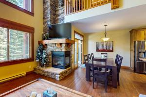 a living room with a fireplace and a dining room table at Snowbanks 2 in Big White