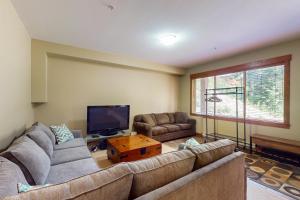 a living room with a couch and a tv at Snowbanks 2 in Big White