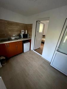 a kitchen with a sink and a refrigerator and a door at Casa Hax Mangalia in Mangalia +13 photos