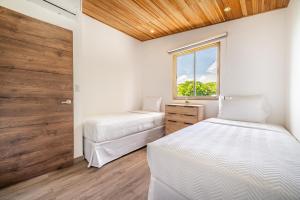 a bedroom with two beds and a window at Macondo Ecolodge Apt 5 - Alpinias in Coco +12 photos