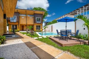 a patio with a table and umbrella next to a house at Macondo Ecolodge Apt 5 - Alpinias in Coco