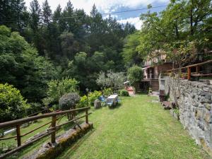 a garden with a stone wall and a wooden fence at Apartment Giallo by Interhome in Il Molinaccio +31 photos