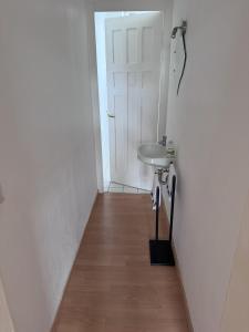 Un pasillo con un lavabo y una puerta blanca. en DUK42a, en Karlsruhe 42 fotos más